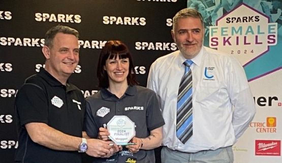 Two white men present a white woman with a plaque for SPARKS female skills