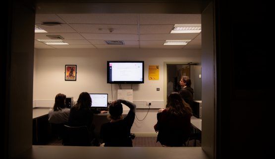 looking into a classroom with students looking at a screen