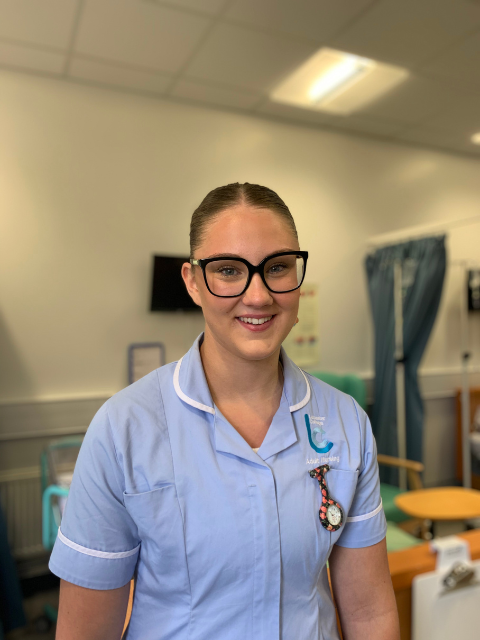 Student Ava in a nurse uniform stood in a the College hospital ward