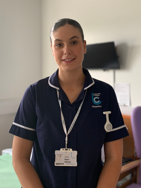 student in midwifery uniform stood in a classroom